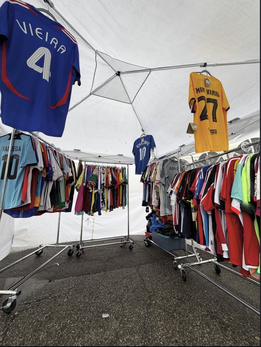 Inside the Myretrokits pop-up tent: rolling racks full of football shirts with Vieira, Ronaldinho and Yamal shirts hanging above