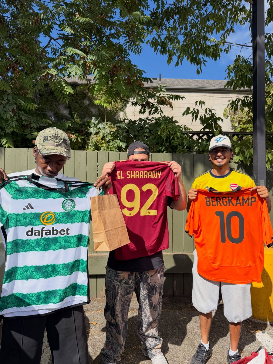 Three customers holding up Celtic, Roma El Shaarawy 92 and Netherlands Bergkamp 10 shirts